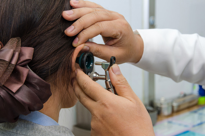 Doctor revisando el oído de una paciente