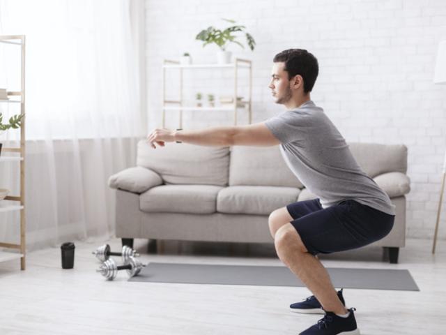 Hombre haciendo sentadillas en casa