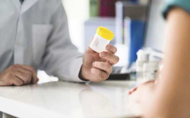 Doctor habla con paciente sobre prueba de orina